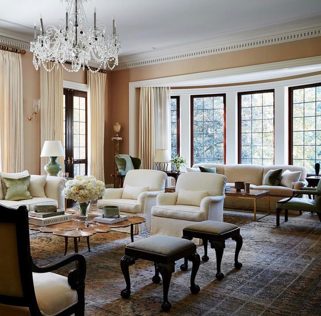 A finished, elegantly painted living room with warm walls, tall windows, and classic furnishings, presented like exhibited artwork