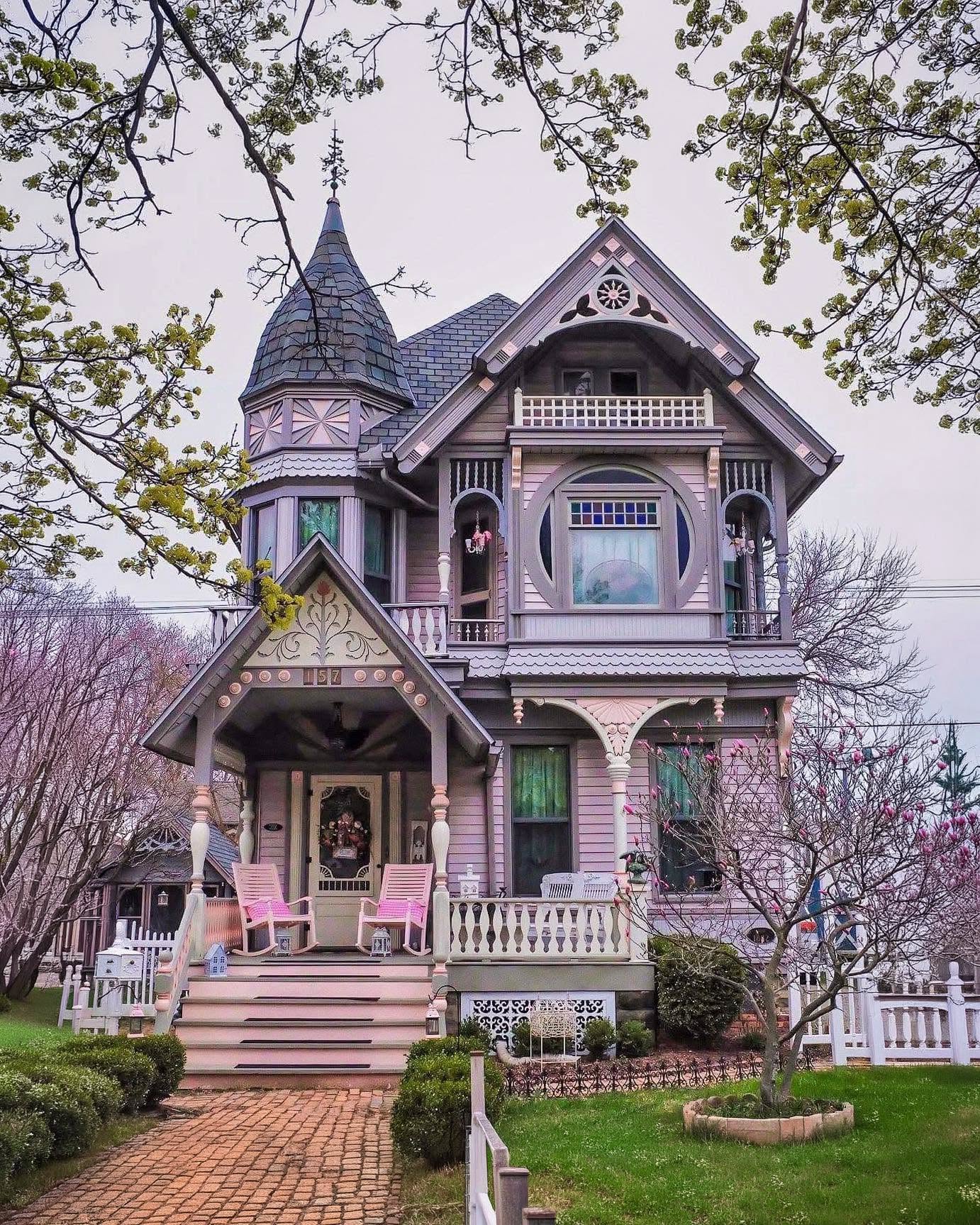 A beautifully painted Victorian home exterior with detailed trim and a welcoming front porch